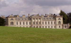 English Palladianism Woburn Abbey, designed by Burlington's student Henry Flitcroft in 1746. Palladio's central temple is no longer free standing, the wings are now elevated to near equal importance, and the cattle sheds terminating Palladio's design are now clearly part of the facade.